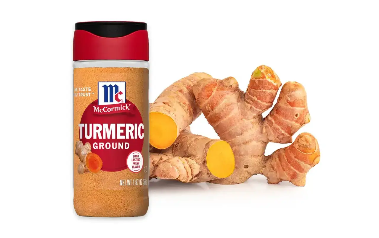 Słoik mielonej kurkumy McCormick i świeży korzeń. Kurkuma na co pomaga? Wzmocnij odporność i dodaj smaku potrawom!