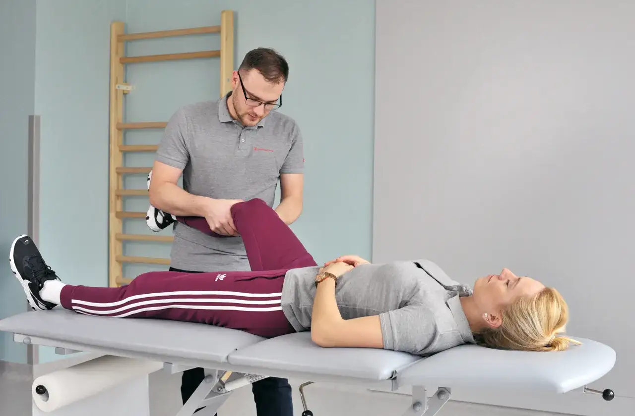 Fizjoterapeuta pomaga pacjentce w ćwiczeniach. Chcesz wiedzieć, gdzie najszybciej na rehabilitacje? Tu uzyskasz pomoc.
