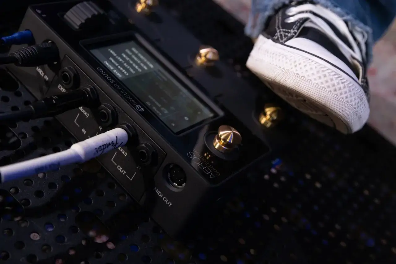 Ein Fu&szlig; auf einem Converse-Schuh tritt auf ein Pedal, das mit einem Musik-Looper verbunden ist.