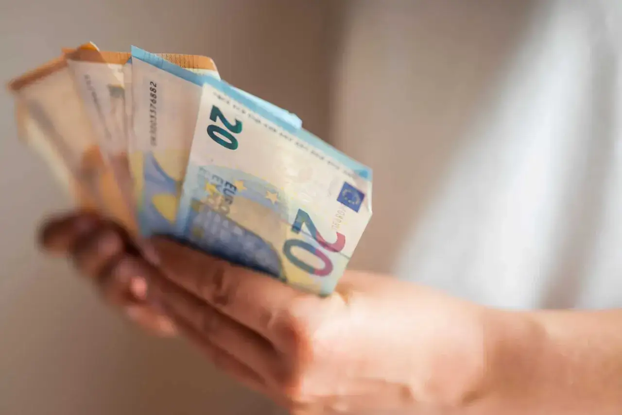 Eine Hand h&auml;lt Euro-Scheine. So kann man mit 12 Jahren Geld verdienen, z.B. durch kleine Jobs oder Taschengeld.