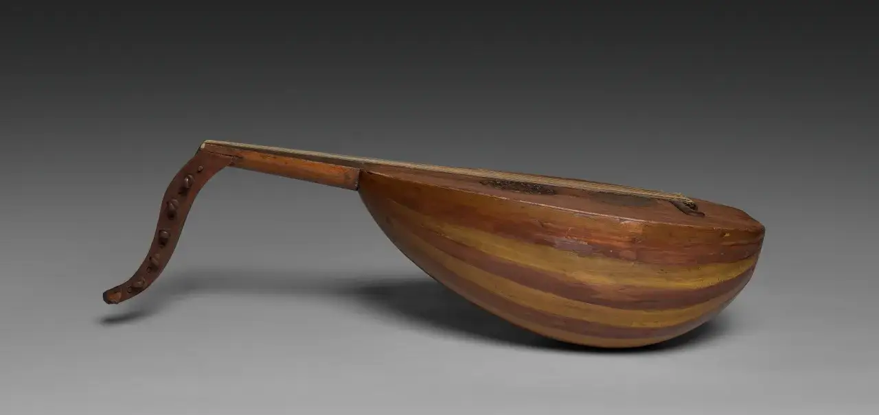 Un oud, instrument &agrave; cordes ancien, aux rayures de bois brun et jaune. Sa caisse de r&eacute;sonance bomb&eacute;e et son manche courb&eacute; &eacute;voquent des m&eacute;lodies d'antan.