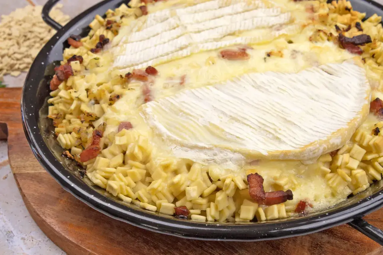 Une délicieuse crozet tartiflette, gratinée au fromage et parsemée de lardons croustillants, prête à être dégustée.