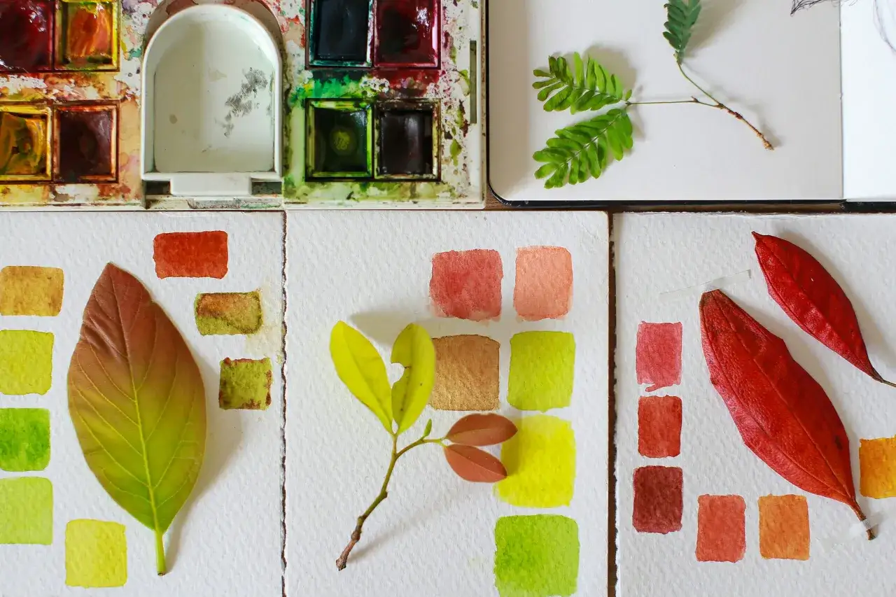 Paleta de acuarela con hojas y muestras de color. El artista experimenta con tonos oto&ntilde;ales para pintar acuarela.
