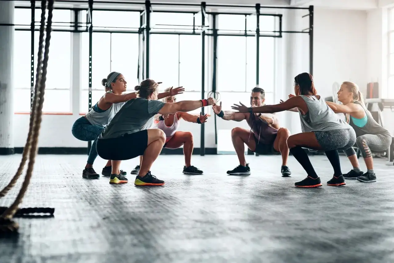 Gruppe macht Kniebeugen im Fitnessstudio. Die Frage