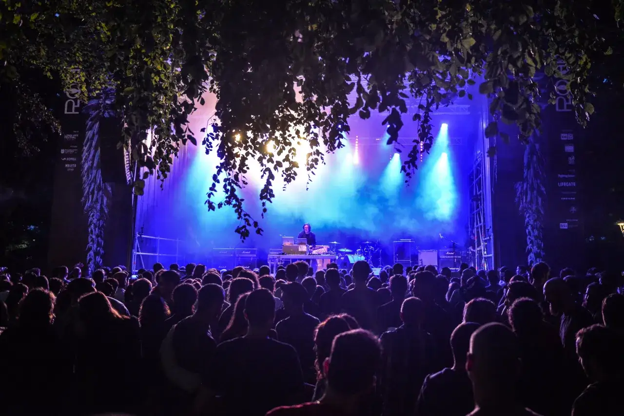 Folla in delirio al Longlake boutique festival, con luci blu e fumo che avvolgono il palco.