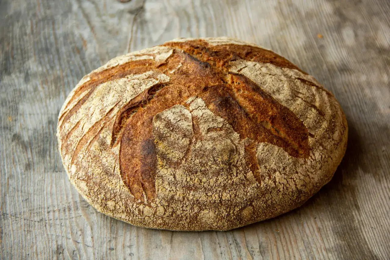 Rustikales Brot aus Vollkornmehl, typisch für Deutschland, liegt auf einer Holzplatte.