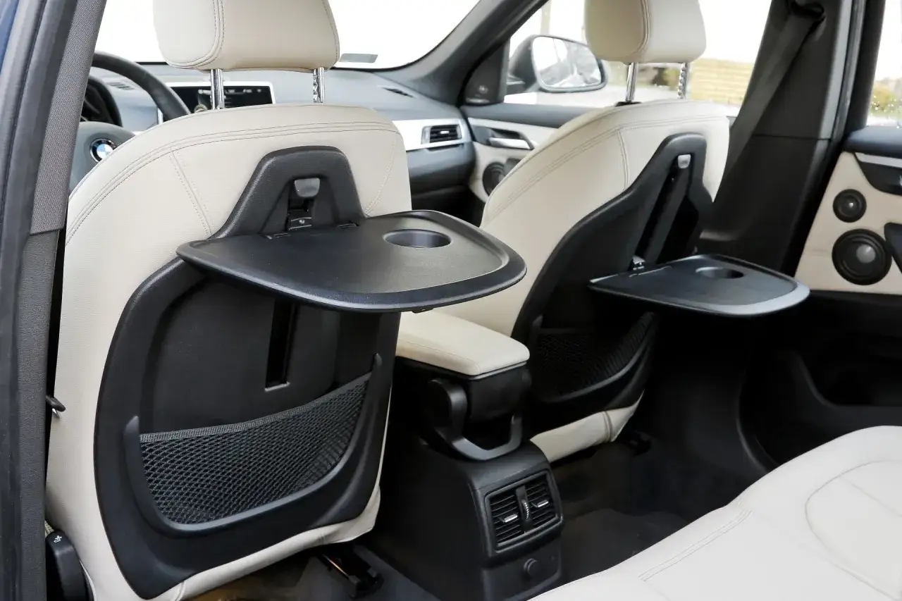 Wnętrze BMW X1 F48 z rozkładanymi stolikami. Wady tego modelu to m.in. ograniczona przestrzeń z tyłu.