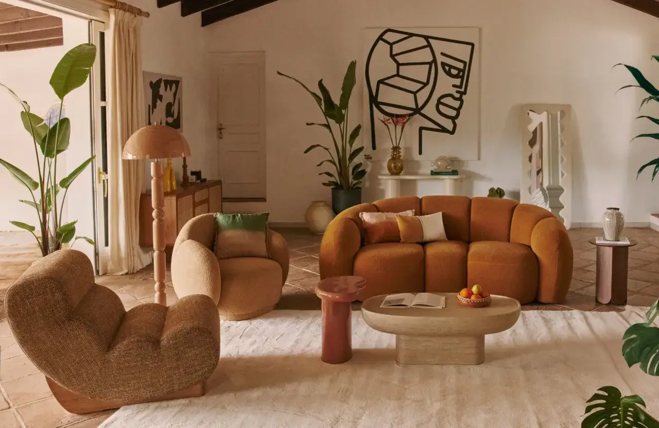 Un salon moderne avec un canapé orange texturé et un fauteuil assorti, illustrant la différence entre divan et canapé par leur design.