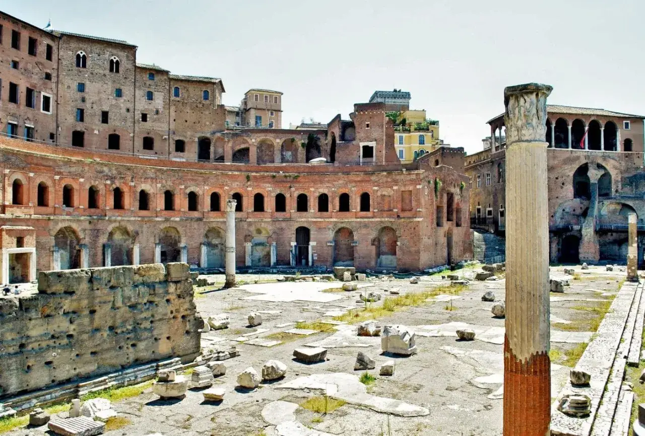 Antico complesso del **Mercato di Traiano** a Roma, con rovine e colonne imponenti sotto un cielo azzurro.