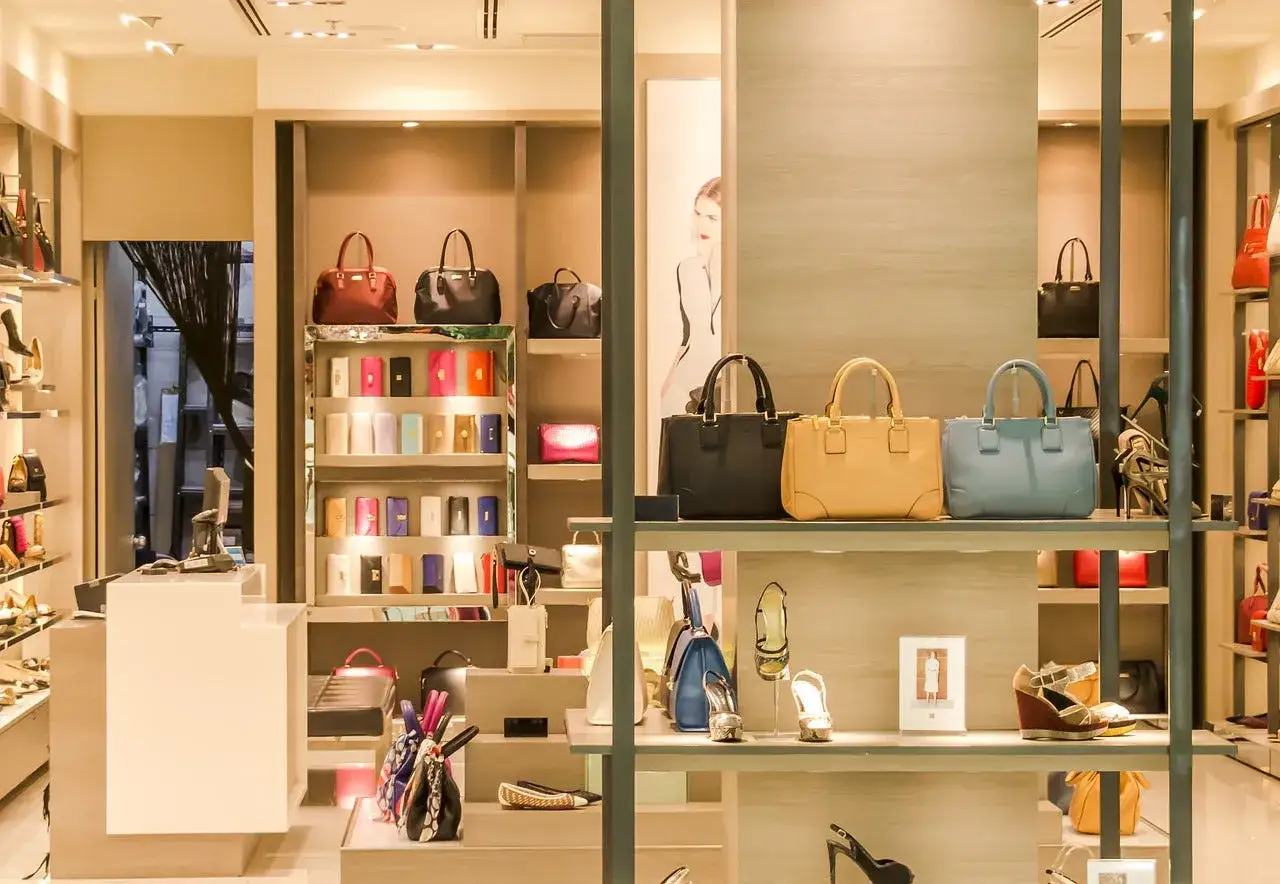 Elegancki butik z torebkami i butami. W witrynie błyszczą drogie marki, kusząc klientki luksusowymi akcesoriami.
