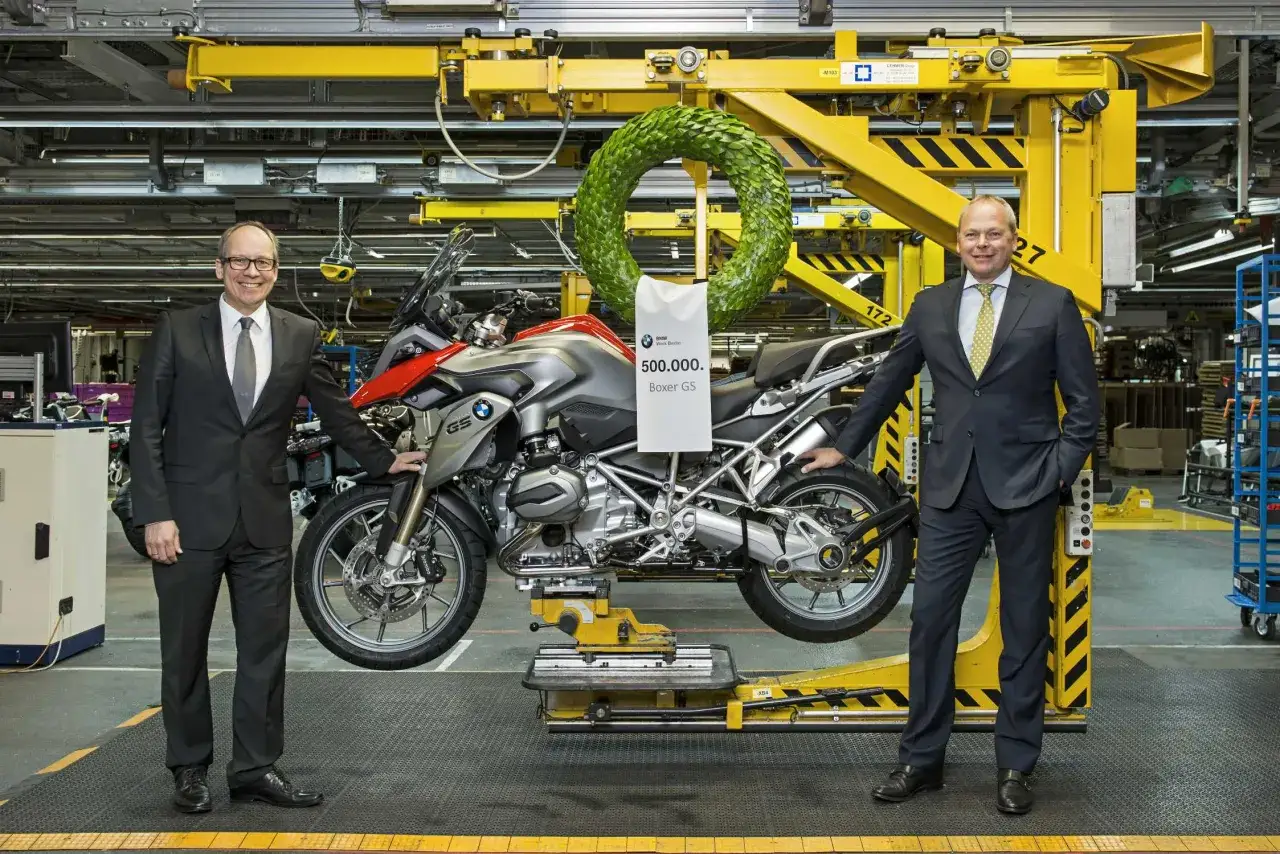 Dwóch mężczyzn świętuje wyprodukowanie 500 000. motocykla BMW Boxer GS. To dowód na niemiecką jakość i precyzję wykonania.