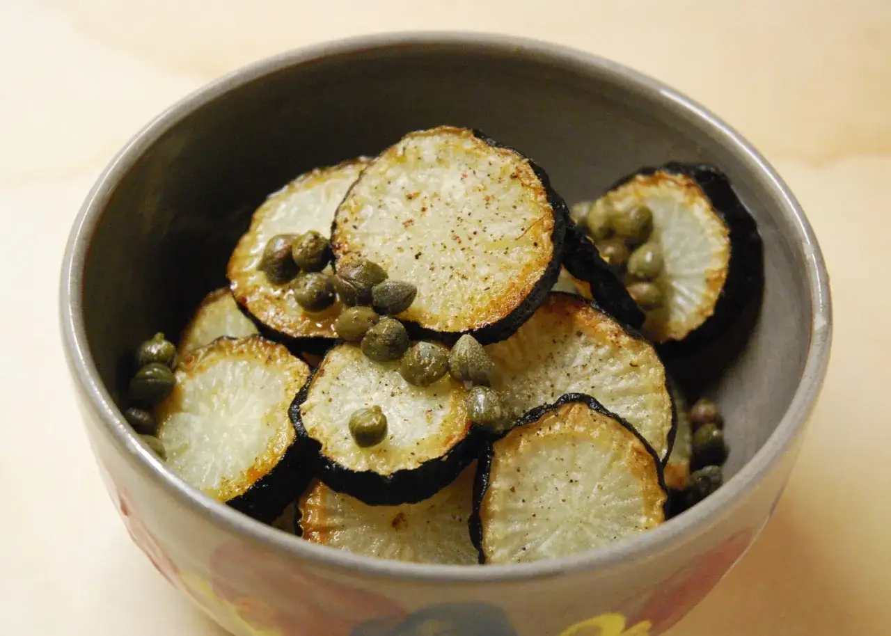 Tranches de radis noir poêlées, garnies de câpres. Une idée simple pour une recette de radis noir savoureuse.