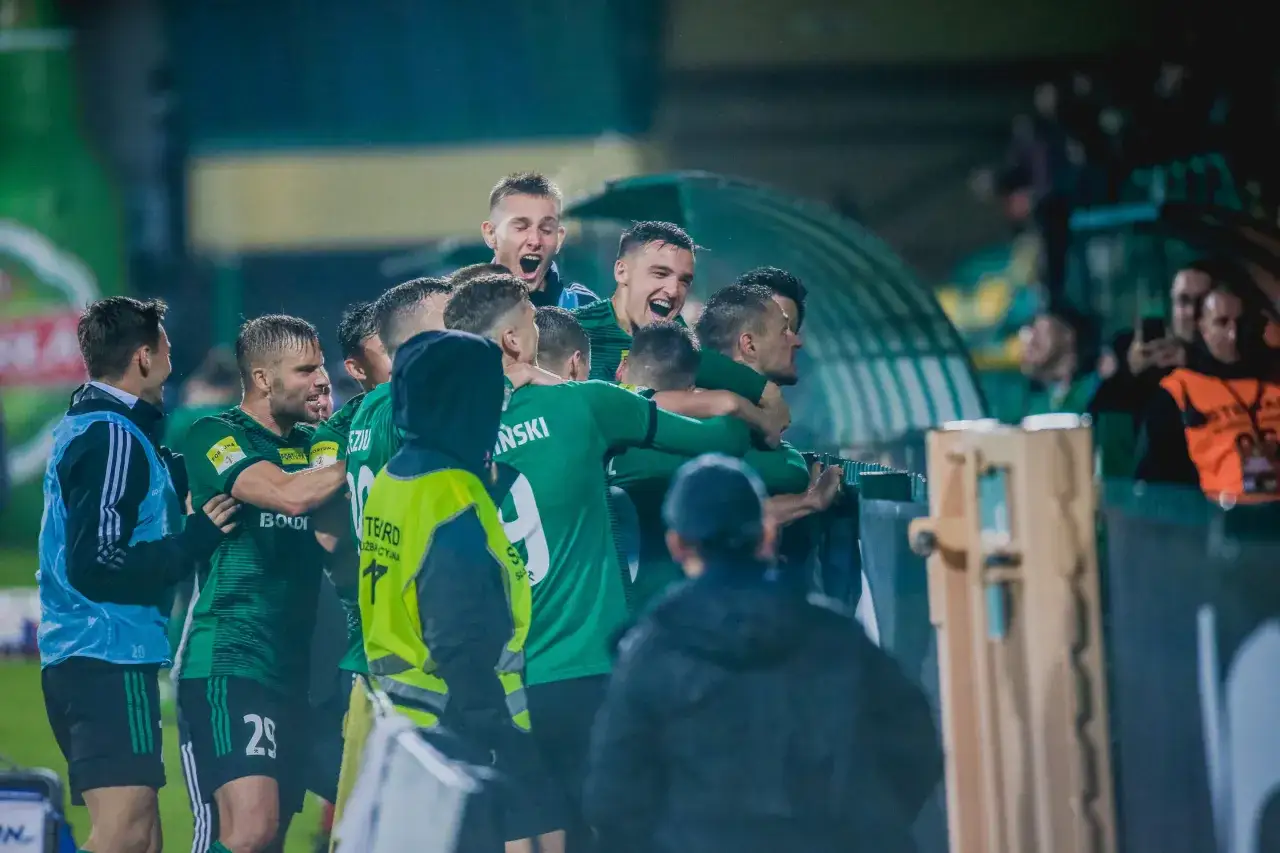 Piłkarze Górnika Łęczna świętują zwycięstwo nad GKS Tychy. Radość na twarzach zawodników, ważny mecz w kontekście rankingów.