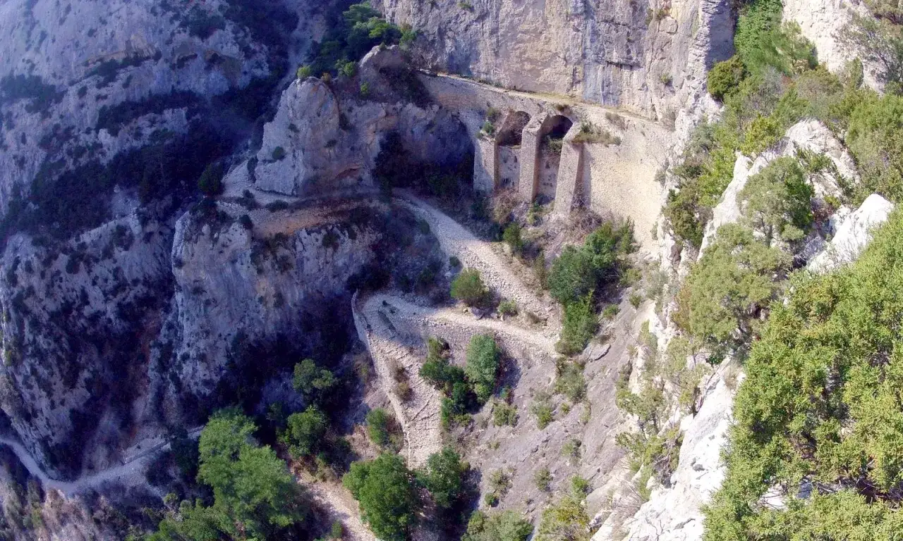 Chemin escarpé et sinueux, idéal pour une rando à Saint-Guilhem-le-Désert, avec des arches de pierre spectaculaires creusées dans la falaise.