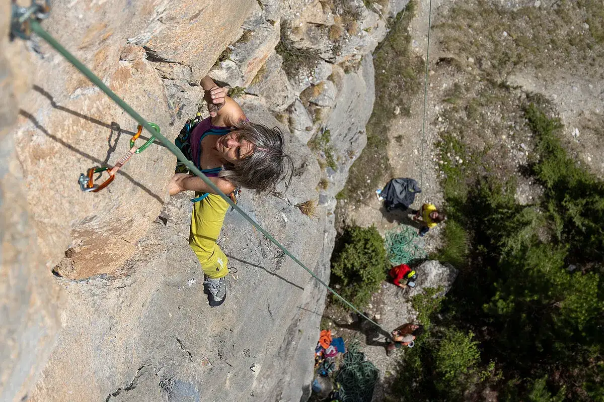 Frau klettert in Brian&ccedil;on, w&auml;hrend unten ein Team wartet.