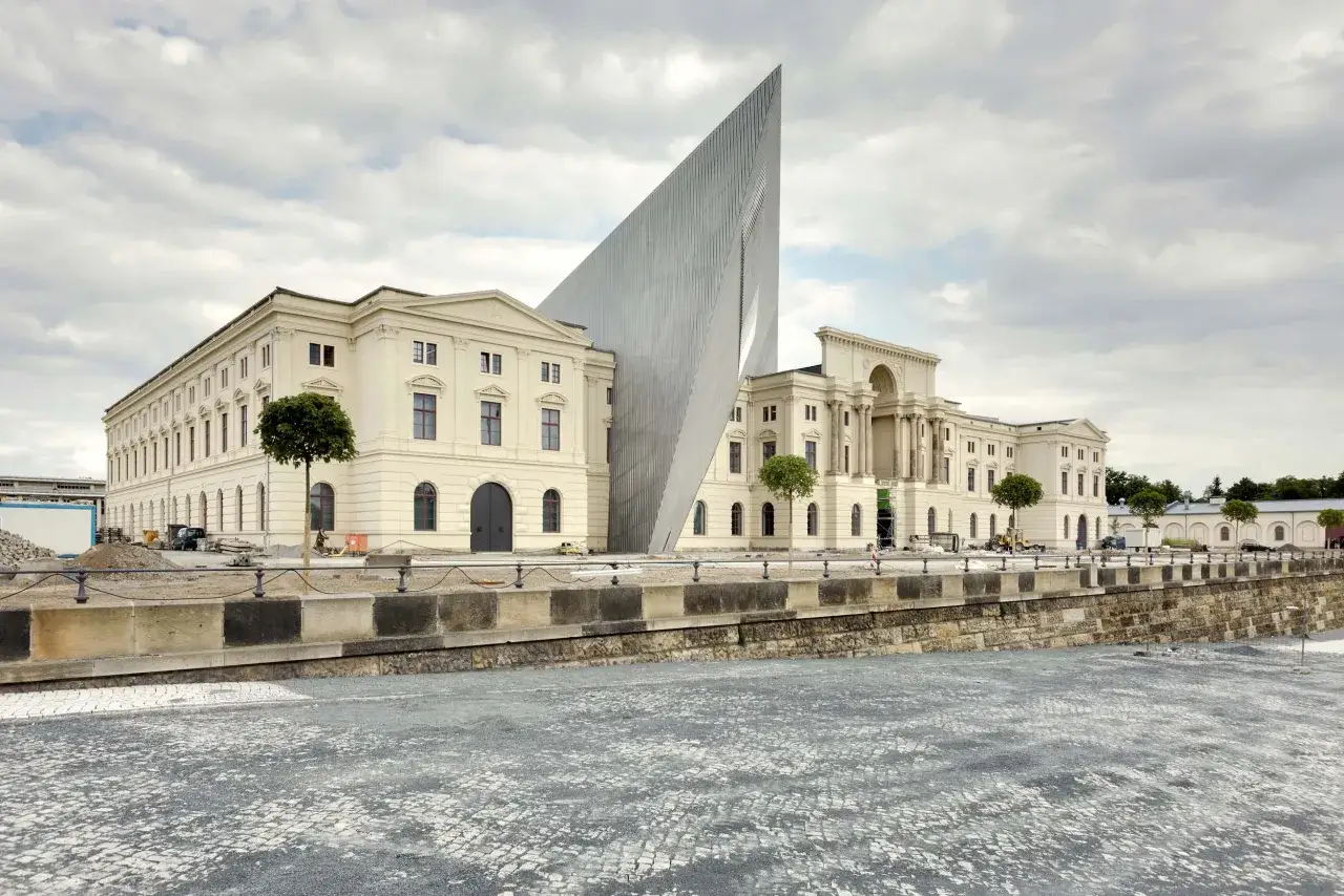 Das Militärmuseum Dresden, ein beeindruckendes Gebäude mit moderner Spitze, steht neben einem historischen Bauwerk.