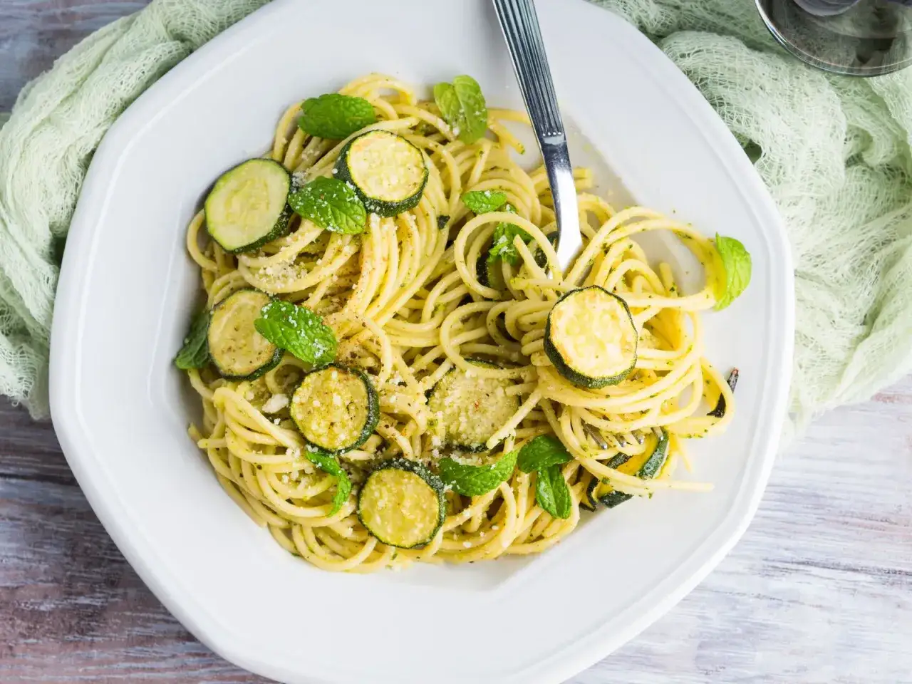 Spaghetti con zucchine, un classico profumato, come la pasta con zucchine ricetta della nonna. Fresca menta e parmigiano completano il piatto.