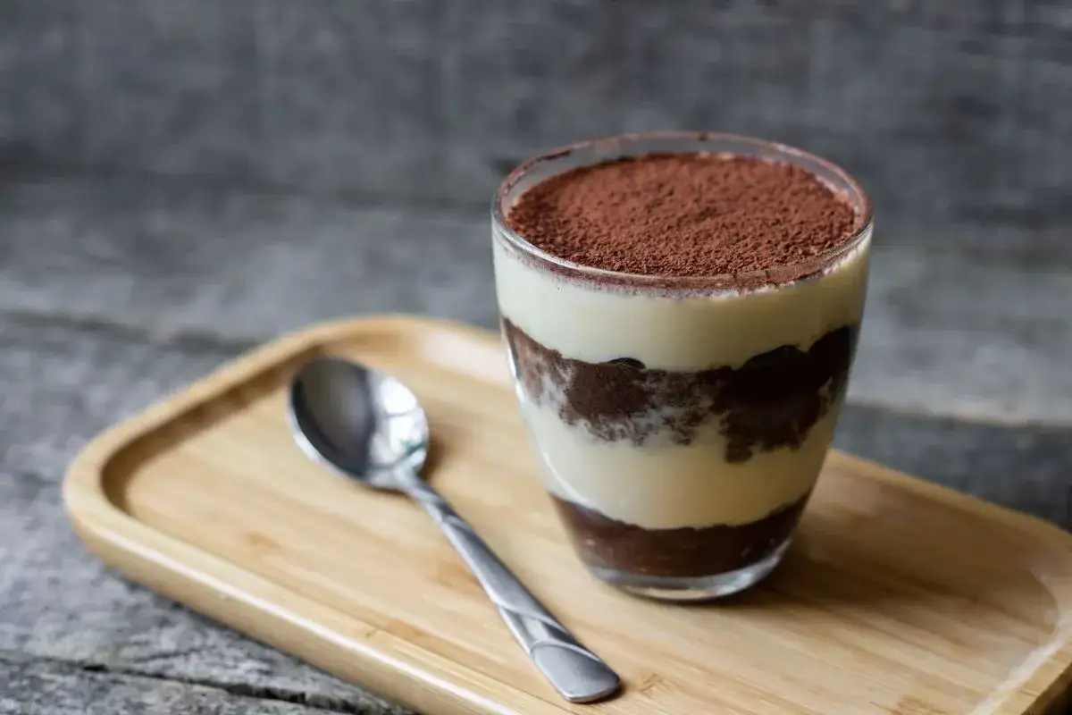 Un bicchiere di tiramis&ugrave;, uno dei dolci da fare in 5 minuti senza cottura, pronto per essere gustato.