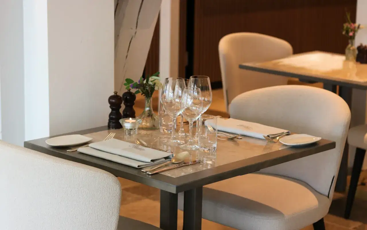 Ett elegant dukat bord på Fjelie Vingård med vinglas, servetter och ljus.
