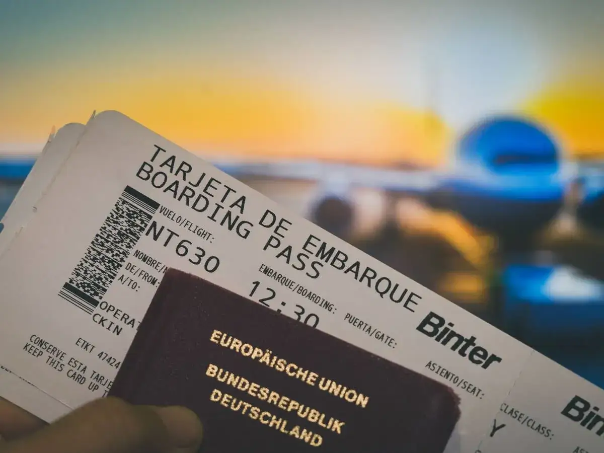 Flugtickets und ein deutscher Reisepass liegen bereit. Ein Flugzeug wartet im Hintergrund, bereit zum Abflug.