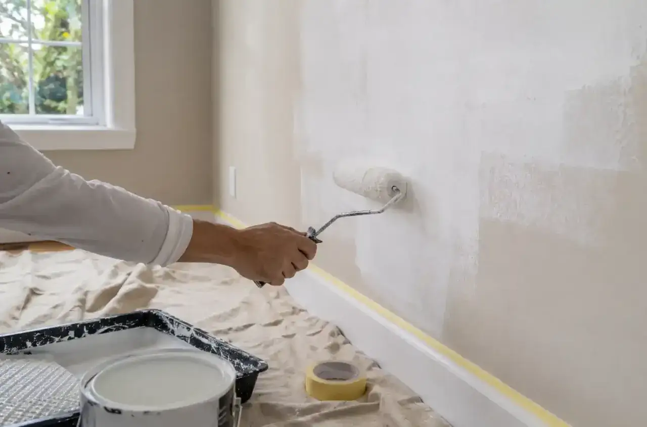 Application d'une sous-couche blanche au rouleau. Le temps de séchage est crucial avant la couche de finition.