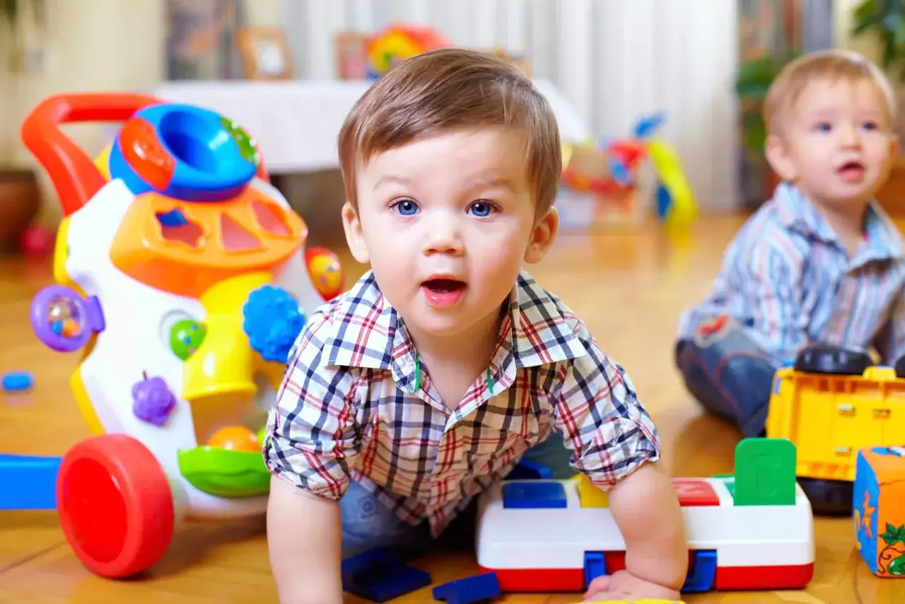 Bambino di 2 anni esplora giocattoli colorati, un carrellino con forme e un camioncino giallo. Attività per bambini di 2 anni stimolanti e divertenti.