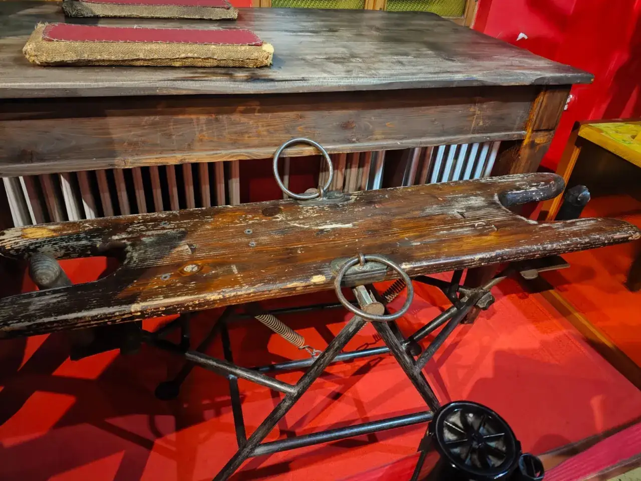 Drewniana kozetka z metalowymi obręczami, część ekspozycji muzeum maszyn erotycznych w Pradze.