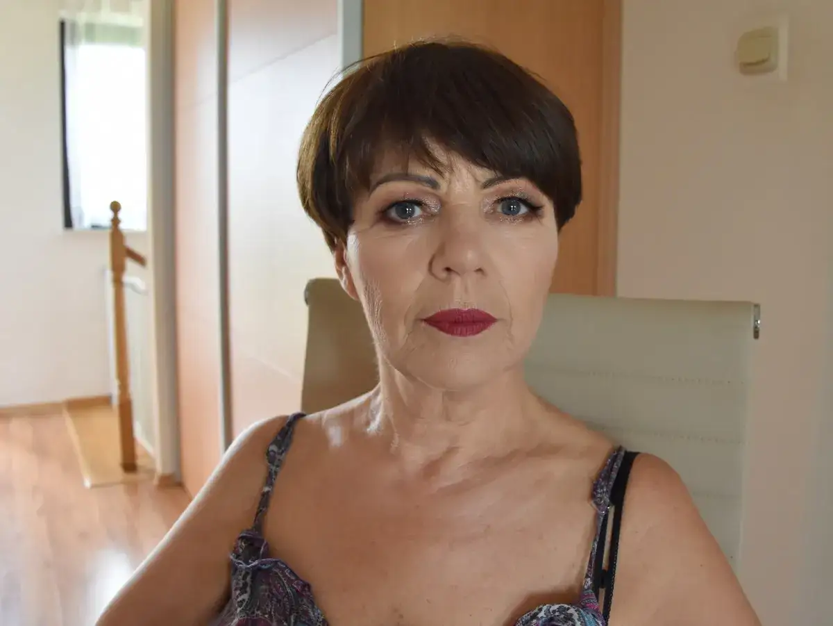 Elegancki makijaż wieczorowy dla 50-latki: podkreślone oczy i matowa, czerwona szminka.