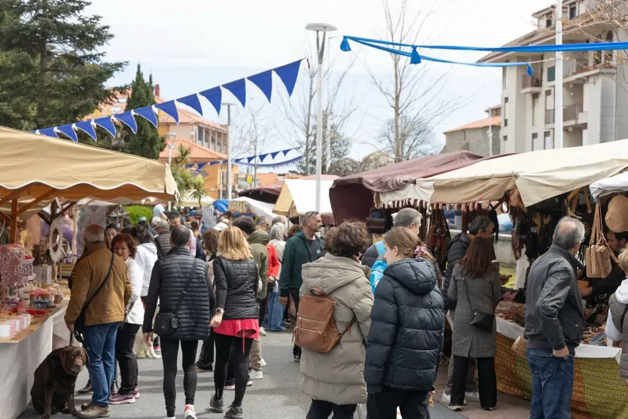 Gente paseando por el mercadillo de Noja, con puestos de artesan&iacute;a y decoraci&oacute;n bajo toldos.