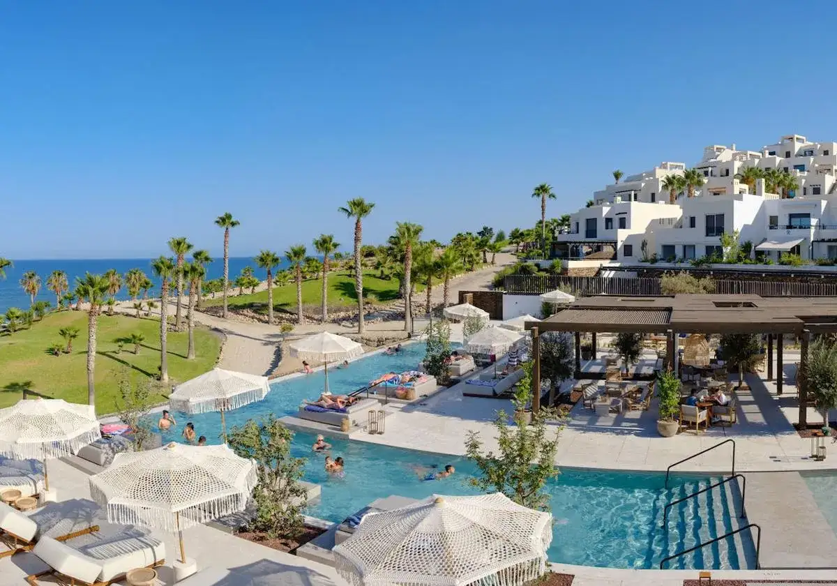 Disfruta del sol y la piscina en el chiringuito Macenas, rodeado de palmeras y con vistas al mar.