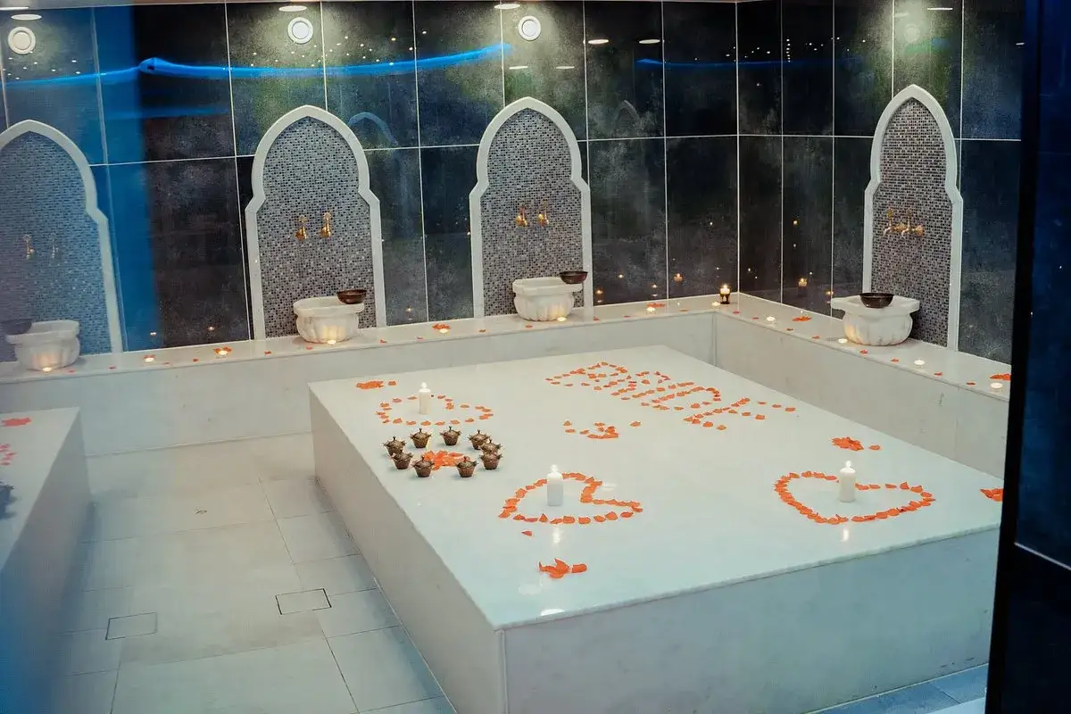 Ett romantiskt norrsken hammam med rosenblad och ljus.
