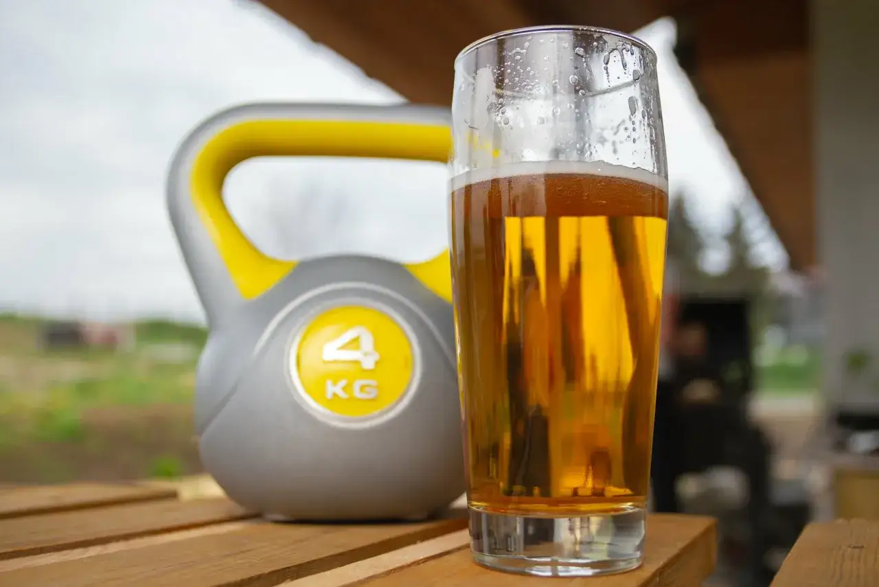 Kettlebell 4kg i szklanka złocistego napoju. Czy piwo bezalkoholowe nawadnia po treningu?