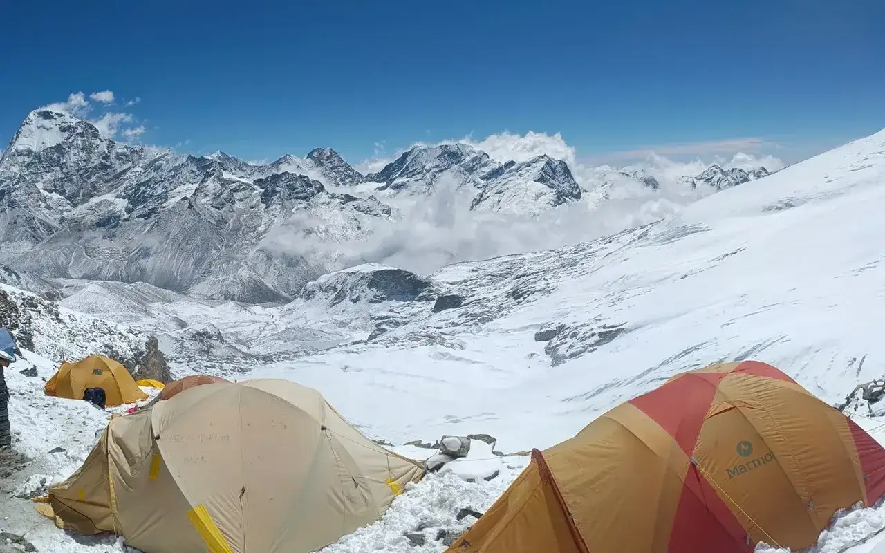Namioty obozowe na tle ośnieżonych szczyt&oacute;w Himalaj&oacute;w, w tym Mera Peak. Widok zapiera dech w piersiach.
