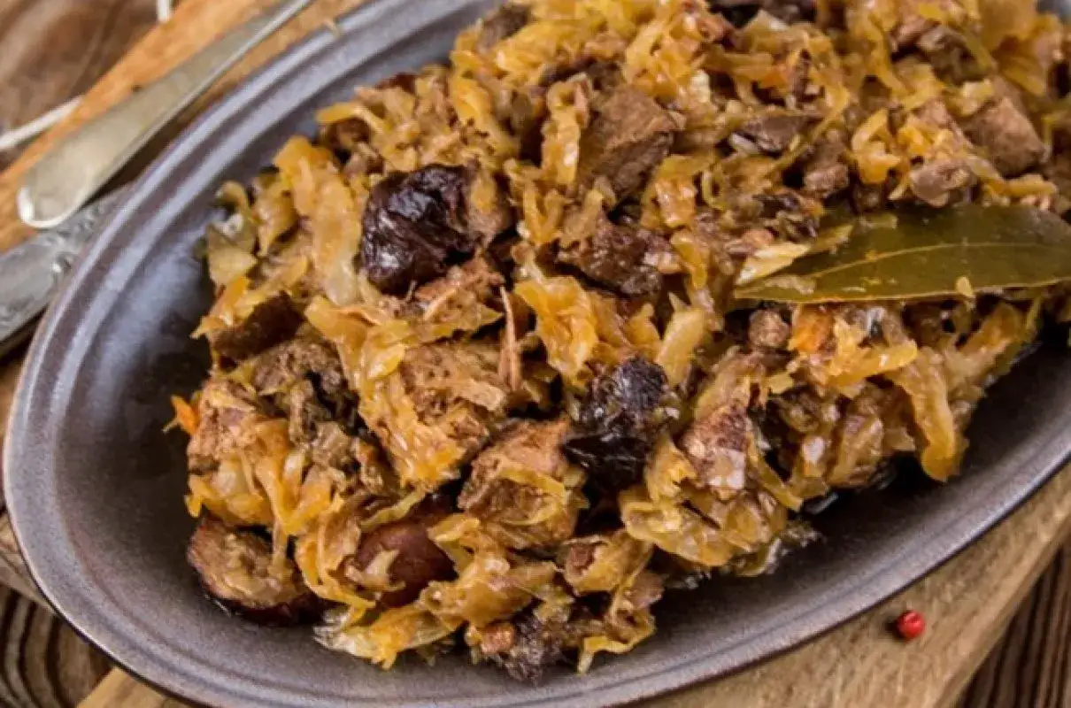 Pyszny bigos z różnymi rodzajami mięsa, kapustą i śliwkami. Idealne danie na zimowe wieczory, pokazujące jakie mięso do bigosu wybrać.
