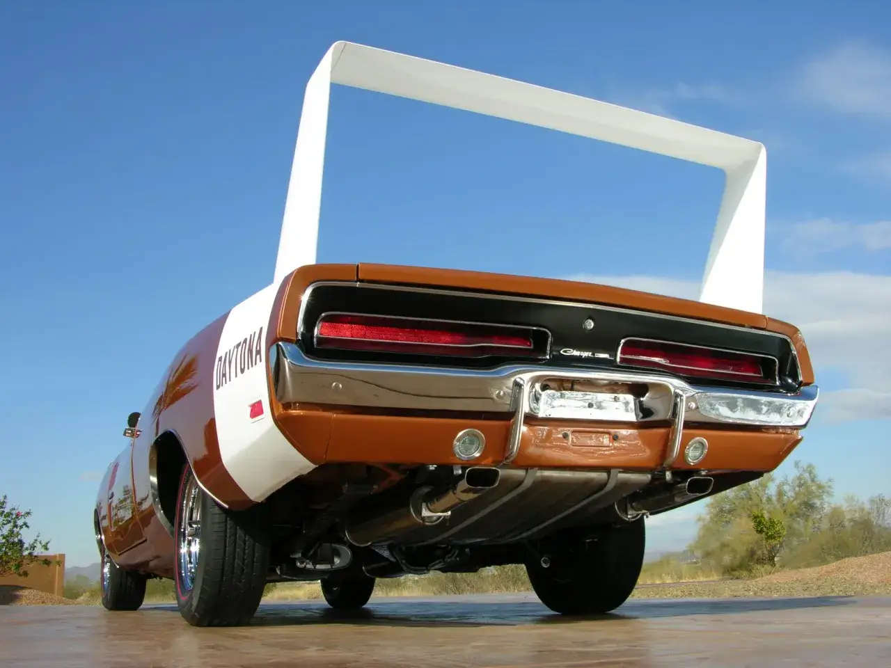 Pomarańczowy Dodge Daytona z charakterystycznym białym spojlerem, widok od tyłu.
