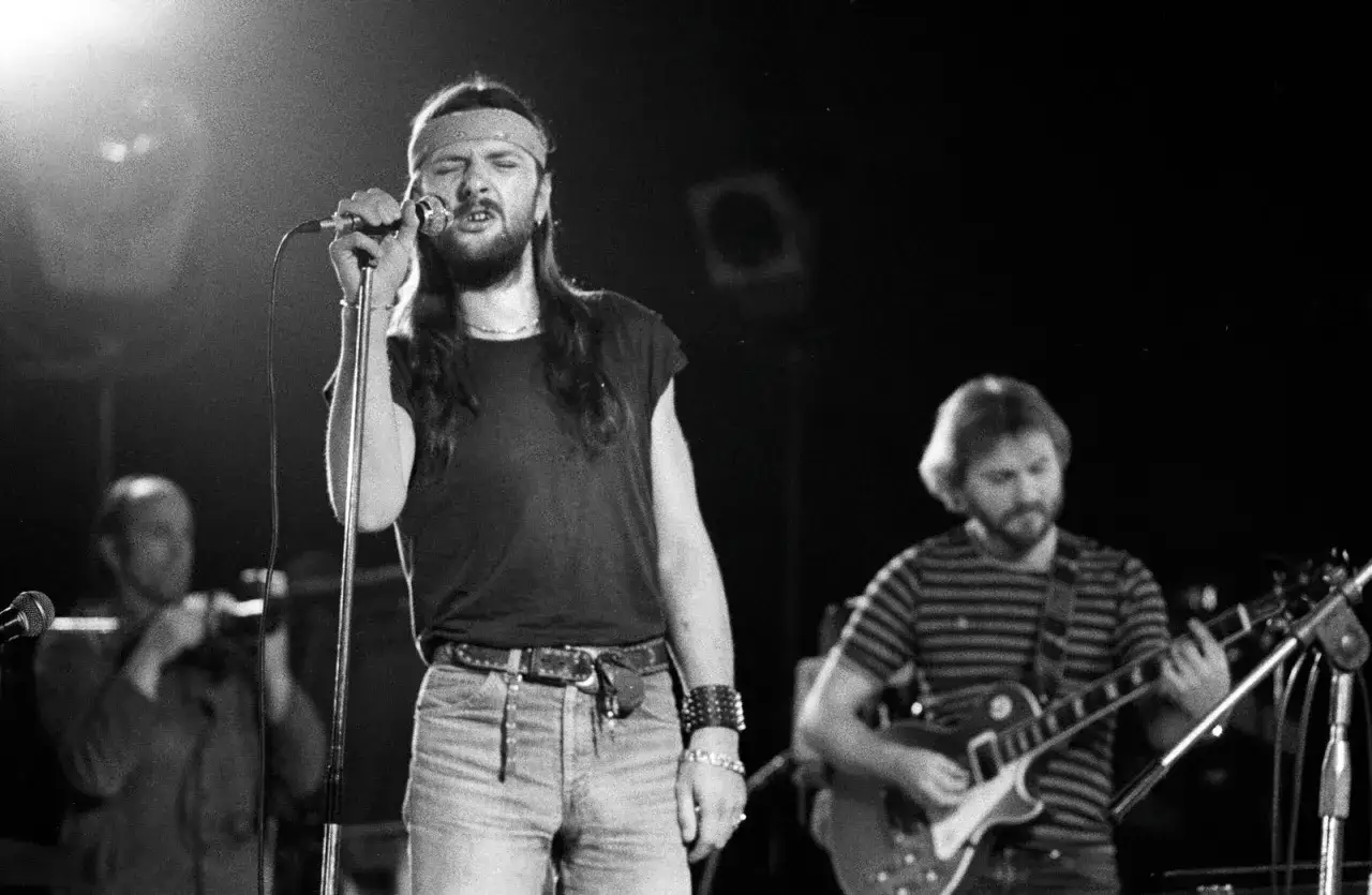 Wokalista z opaską na głowie śpiewa do mikrofonu, obok gitarzysta. W tamtych chwilach marzeniami żyłem jak król.