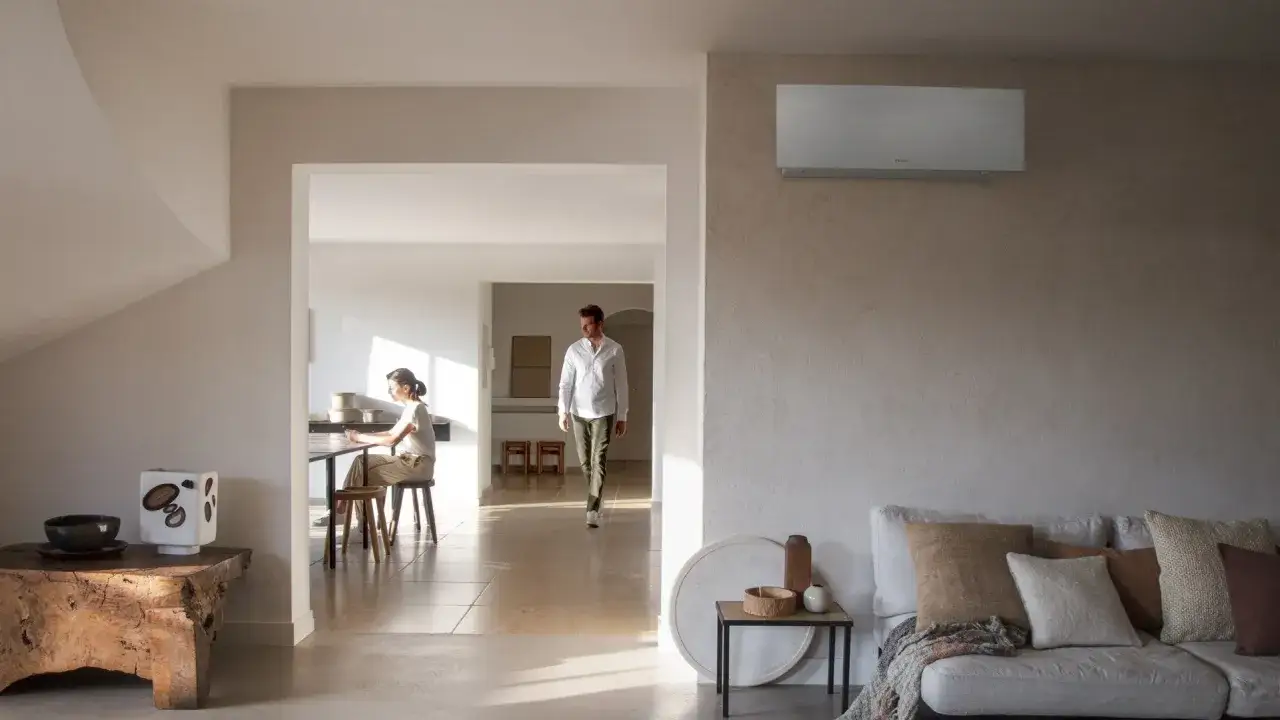 Un hombre y una mujer en un hogar moderno. El aire acondicionado en la pared sugiere que la pregunta de cuanto dura un aire acondicionado es relevante para el confort.