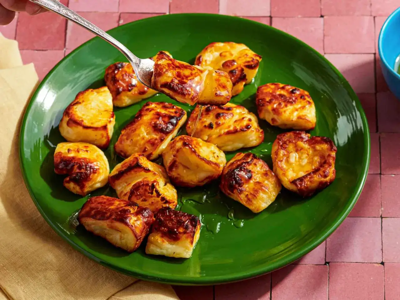 Halloumi i airfryer, gyllene och krispiga, ringlade med honung p&aring; en gr&ouml;n tallrik.