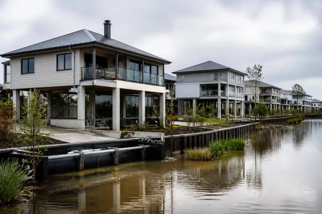 Maisons sur pilotis le long d'un canal, illustrant la valeur d'une maison en zone inondable.