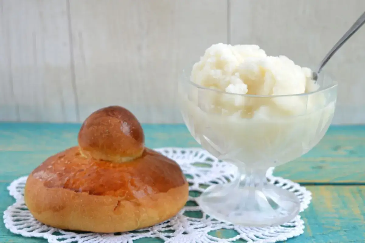 Brioche soffice accanto a una coppa di fresca granita al limone, un classico siciliano per rinfrescarsi.