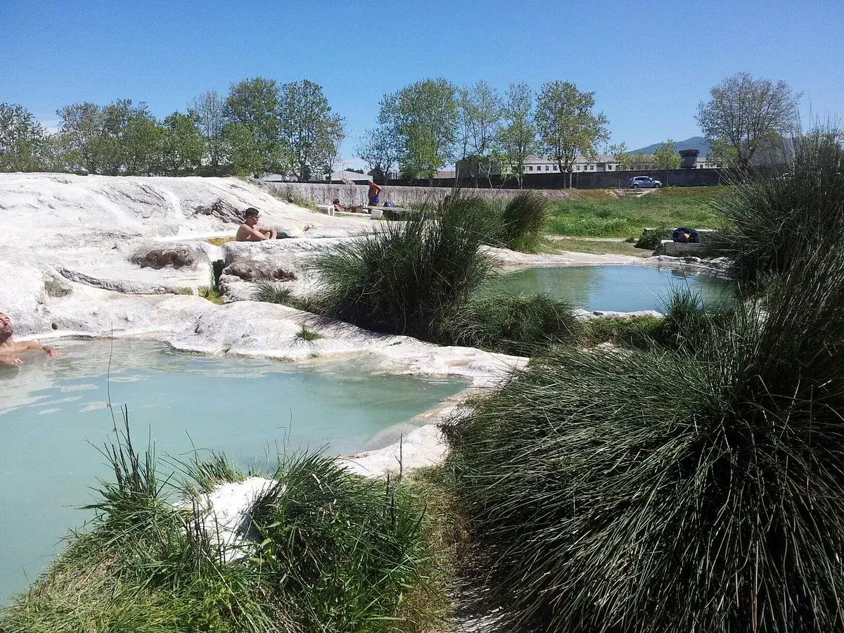 Relax in the **piscine carletti**, natural thermal pools surrounded by lush greenery and white rocks.
