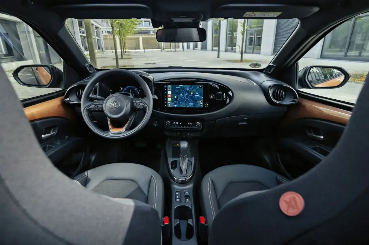 Wnętrze Toyoty Aygo. Kierownica, ekran multimedialny z nawigacją, fotele. Czy warto kupić? Sprawdź toyota aygo opinie.