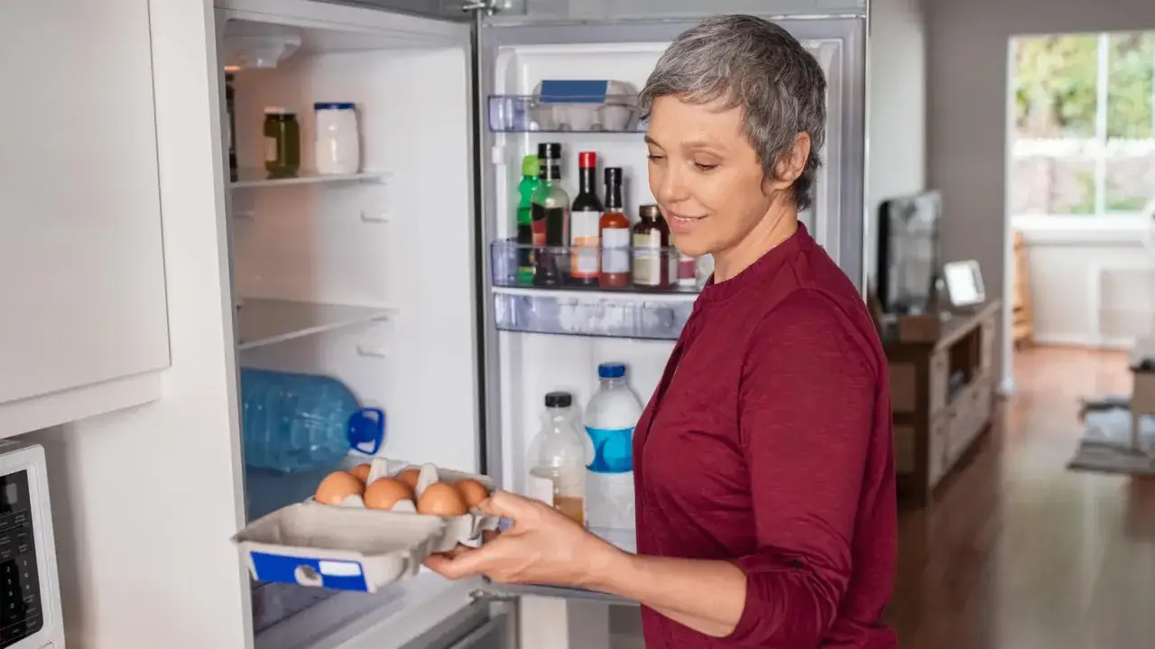Frau holt Eier aus dem Kühlschrank. Nach der Darmspiegelung ist leichte Kost wichtig, Eier sind eine gute Wahl für das Essen nach darmspiegelung.
