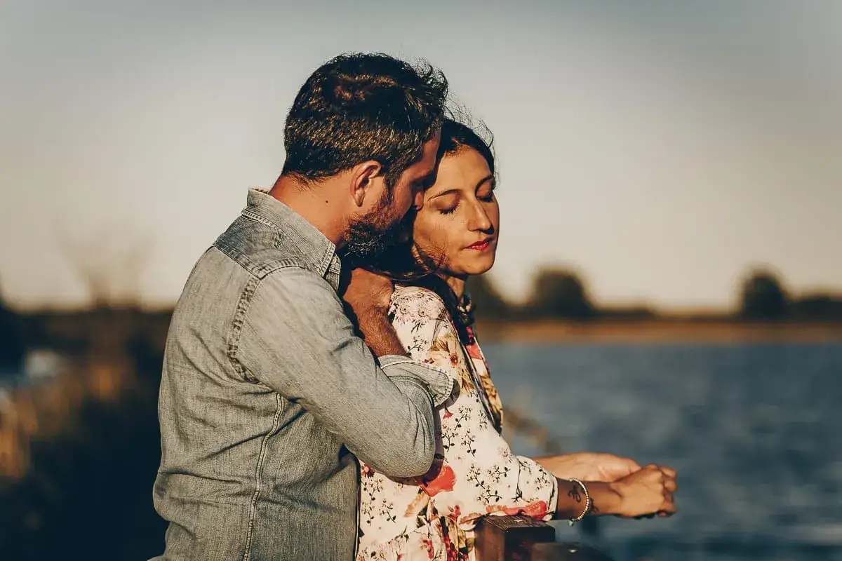 Coppia abbracciata al tramonto, un momento di serenità che insegna come gestire la gelosia con amore e fiducia.