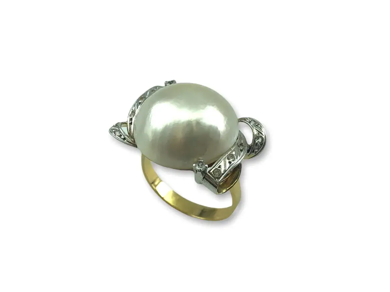 Anillo de oro con un gran anillo perla japonesa central, rodeado de pequeños diamantes incrustados en filigrana de plata.