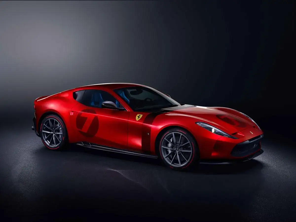 Ein roter Ferrari Omologata mit der Nummer 7 auf der Seite, vor dunklem Hintergrund.