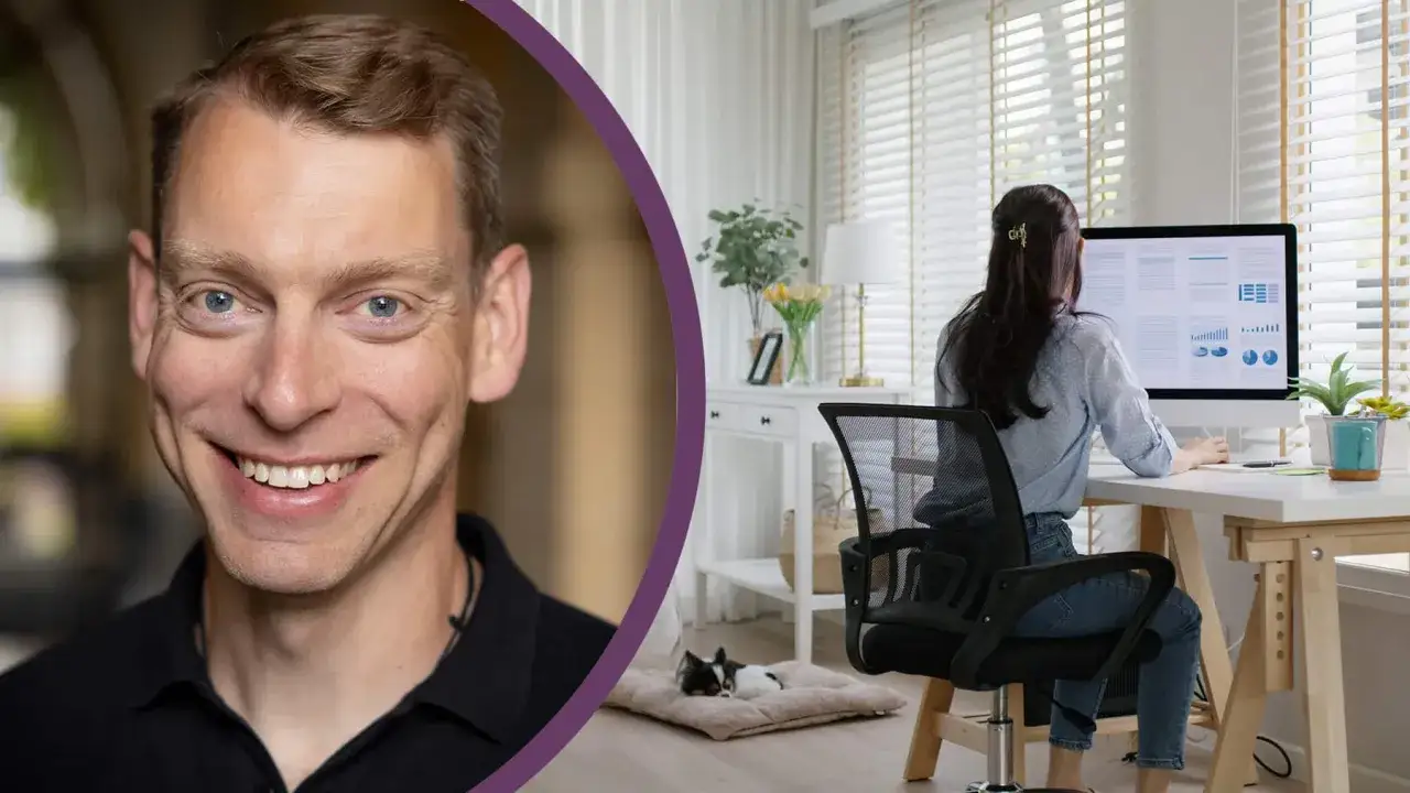 Man ler, medan en kvinna arbetar ergonomiskt vid sin dator. En liten hund vilar på golvet.