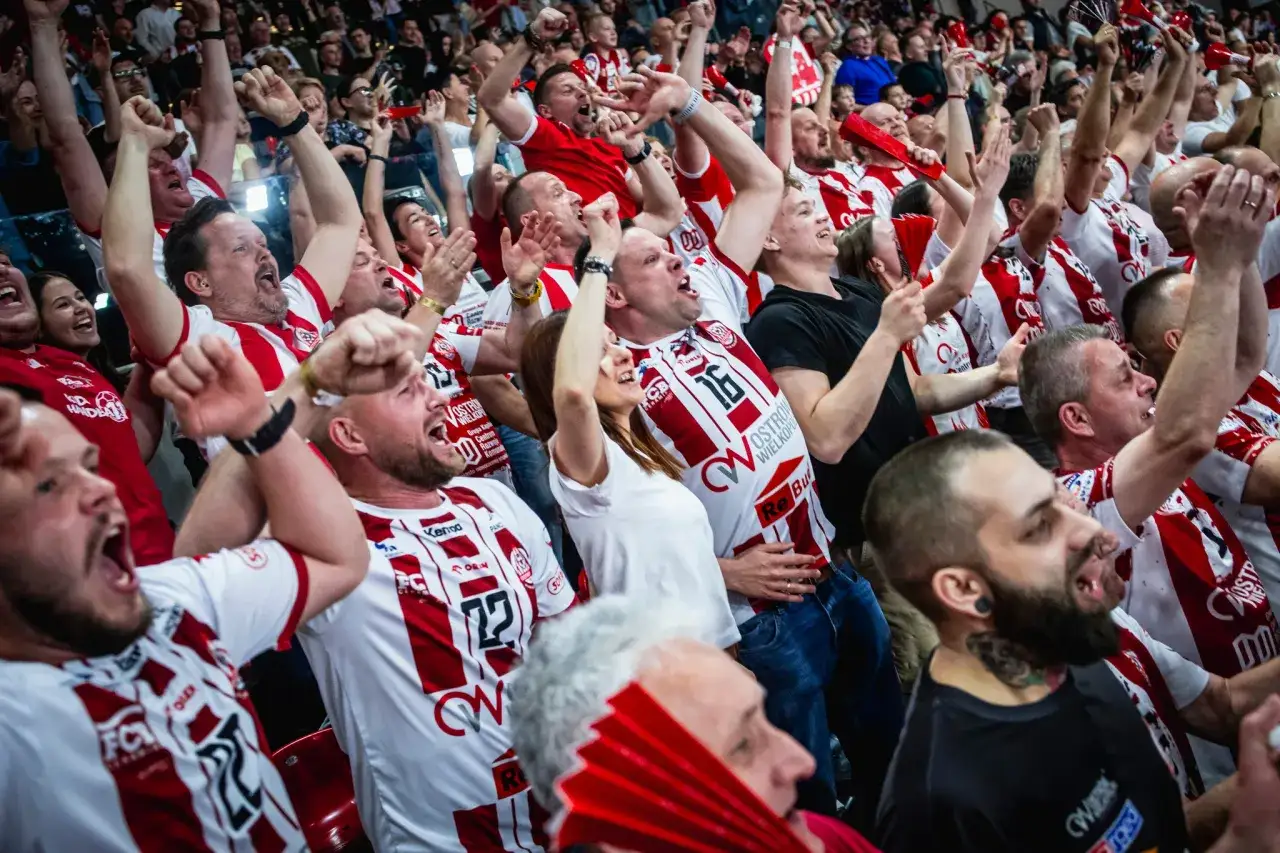 Emocje na trybunach! Kibice Ostrovii piłka ręczna świętują zwycięstwo, krzycząc i unosząc ręce.