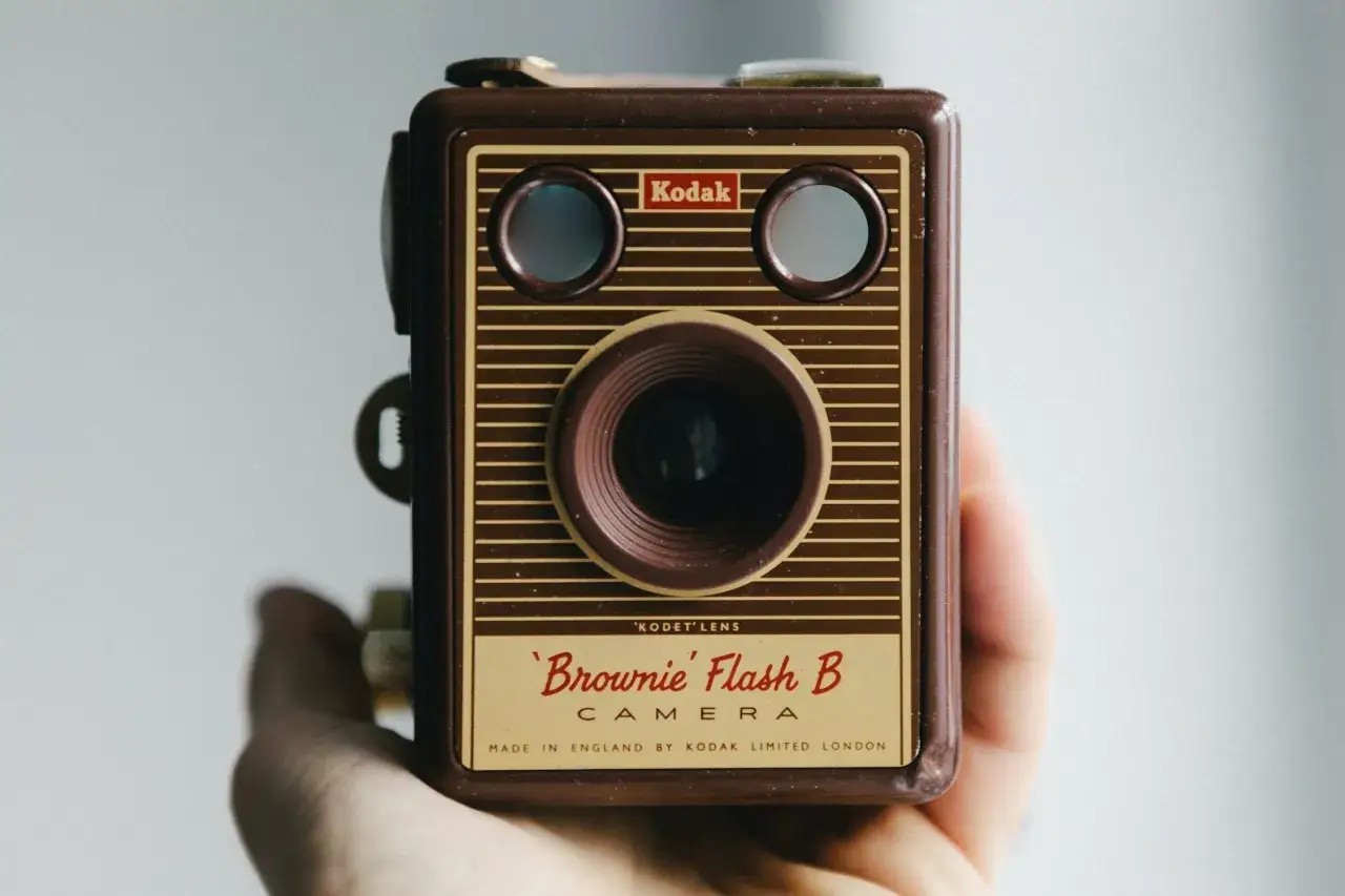 Retro aparat Kodak Brownie Flash B, trzymany w dłoni. Klasyk firmy Kodak.