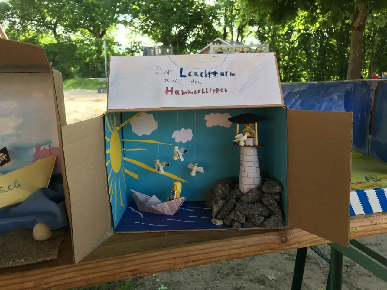 Kreative buchvorstellung klasse 2: Ein Leuchtturm auf den Hummerklippen mit Schiff und M&ouml;wen.
